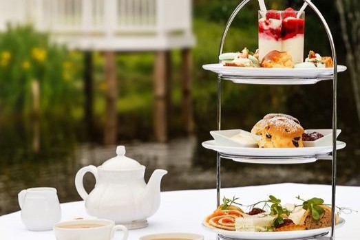 A three tier afternoon tea stand of sandwiches, scones and cakes at Sheene Mill